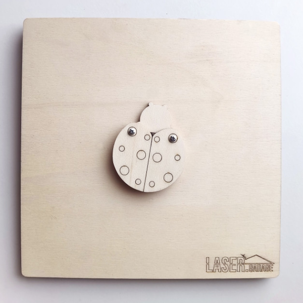 Drevená lienka so zrkadielkom na doske