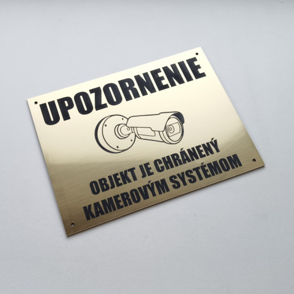 zlatá tabuľka Upozornenie – objekt je chránený kamerovým systémom