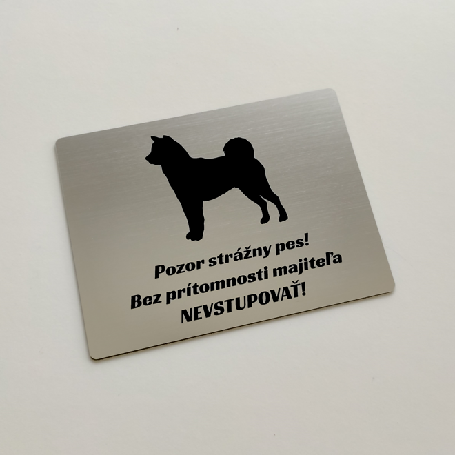 Strieborná tabuľka so siluetou shiba inu a nápisom Pozor strážny pes