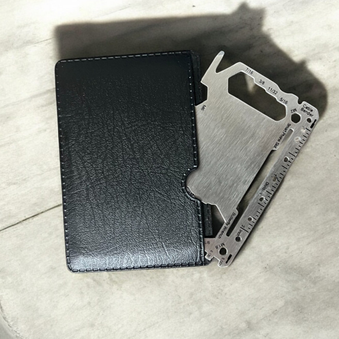 Nerezová multitool karta vysunutá z čierneho koženého puzdra
